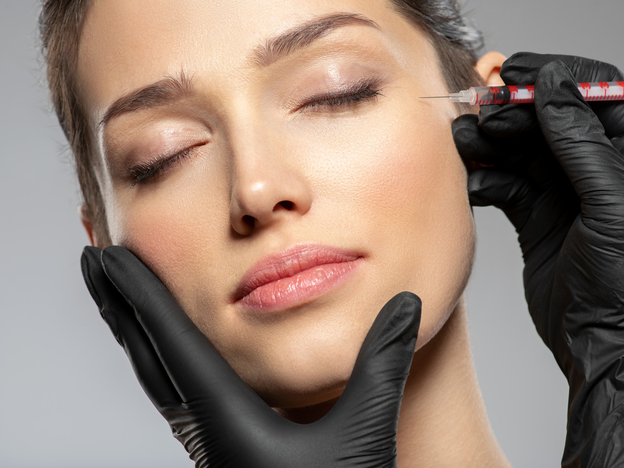Caucasian woman getting botox cosmetic injection in forehead. Woman gets botox injection in her face